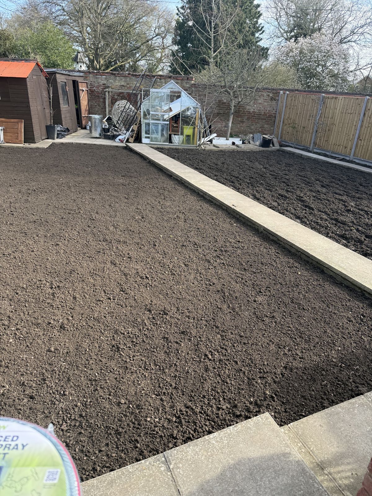 The same garden cleared and levelled to bare soil, ready for a new lawn